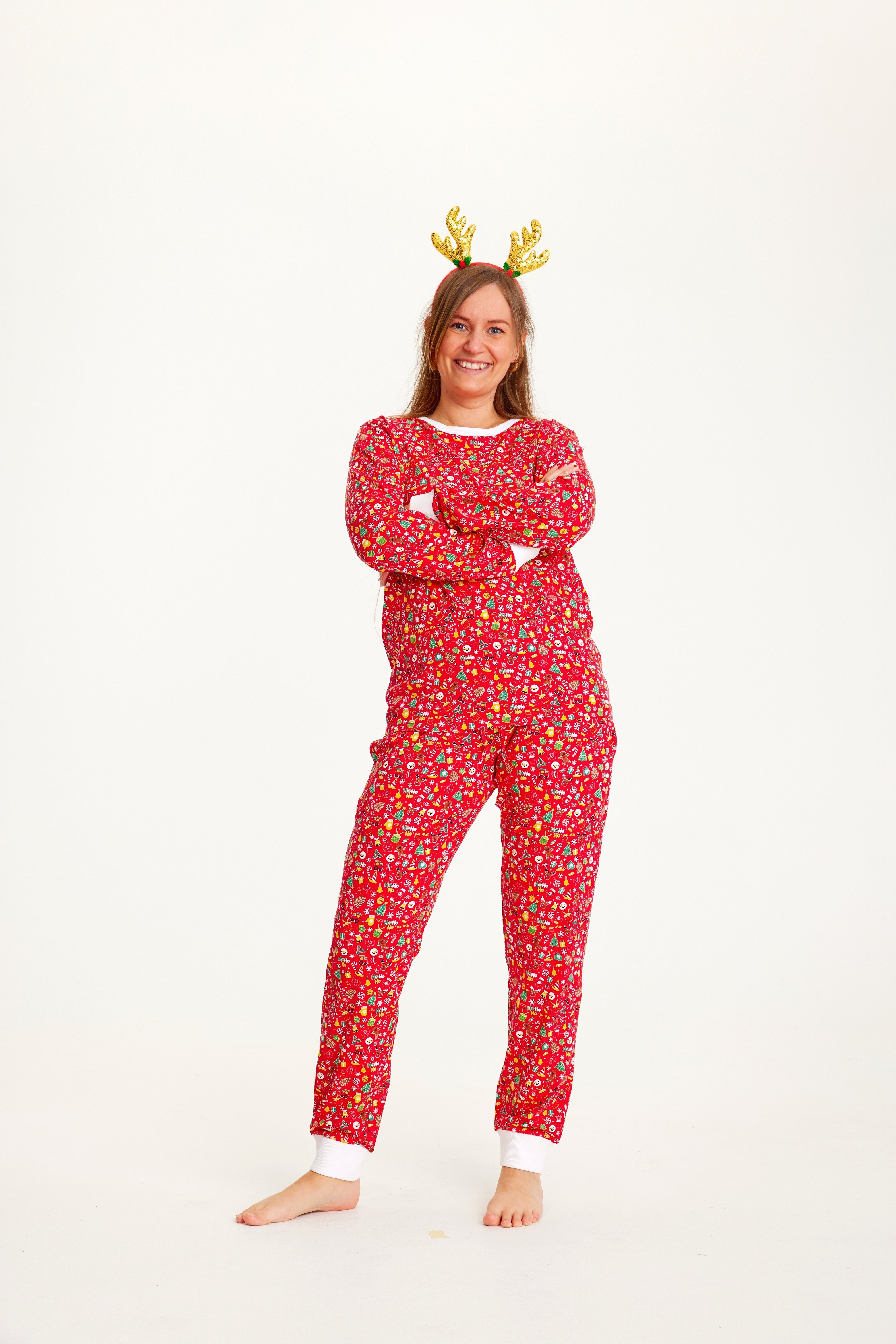 En dam i en röd julpyjamas med julsaker på.
